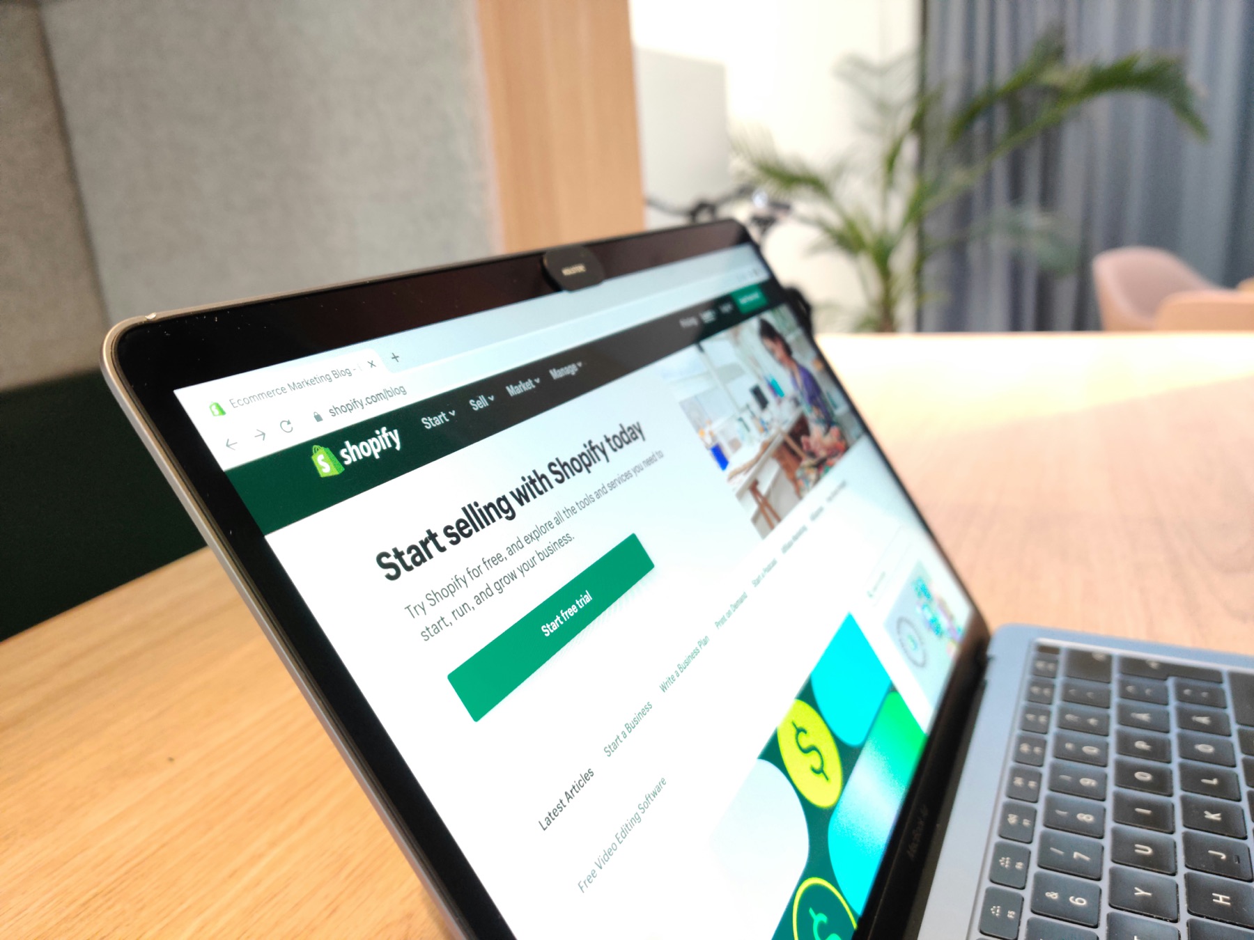 Laptop displaying the Shopify website on a desk