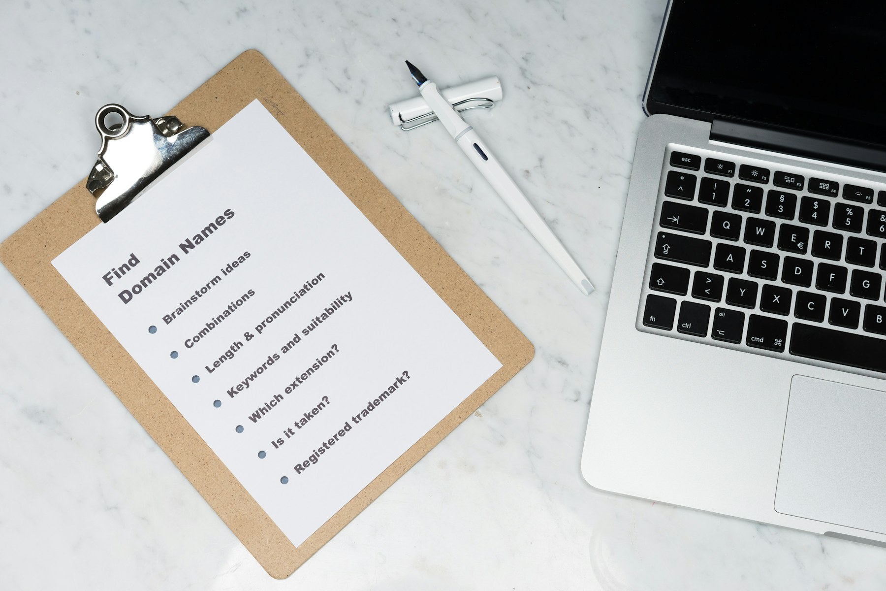 Domain name planning checklist beside a laptop