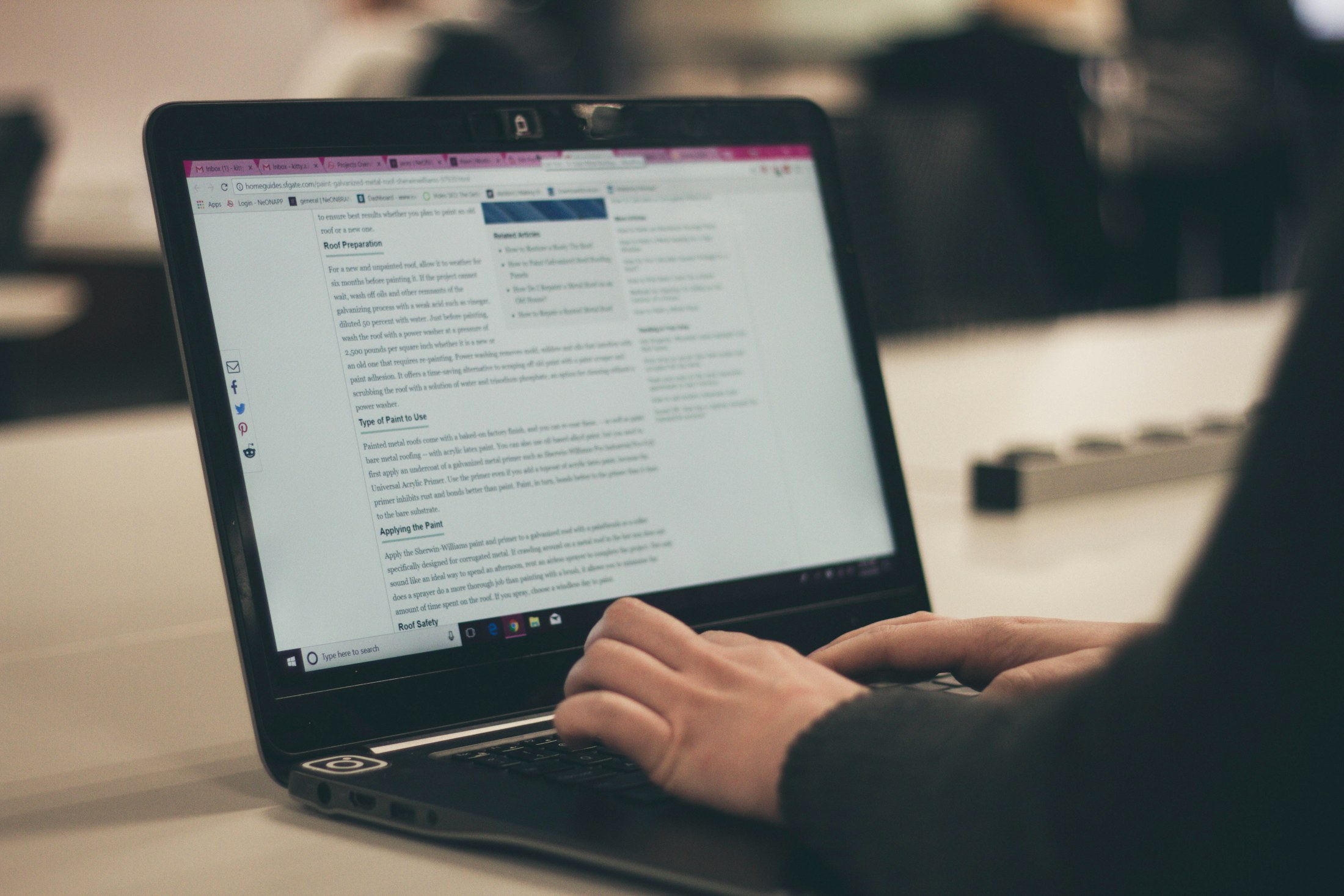 Person typing on a laptop while researching an article