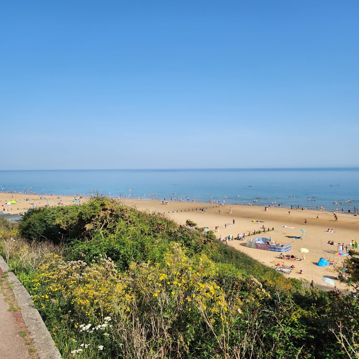 A sunny British beach with golden sand and blue sea