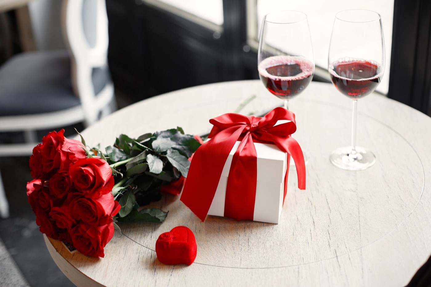 Red roses, a wrapped gift and wine for Valentine's Day