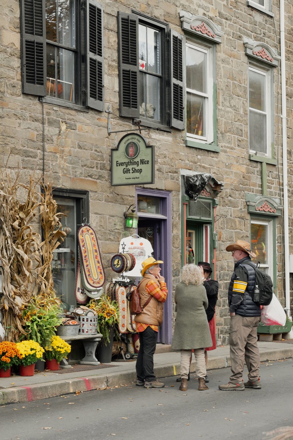 People outside a local gift shop decorated for autumn