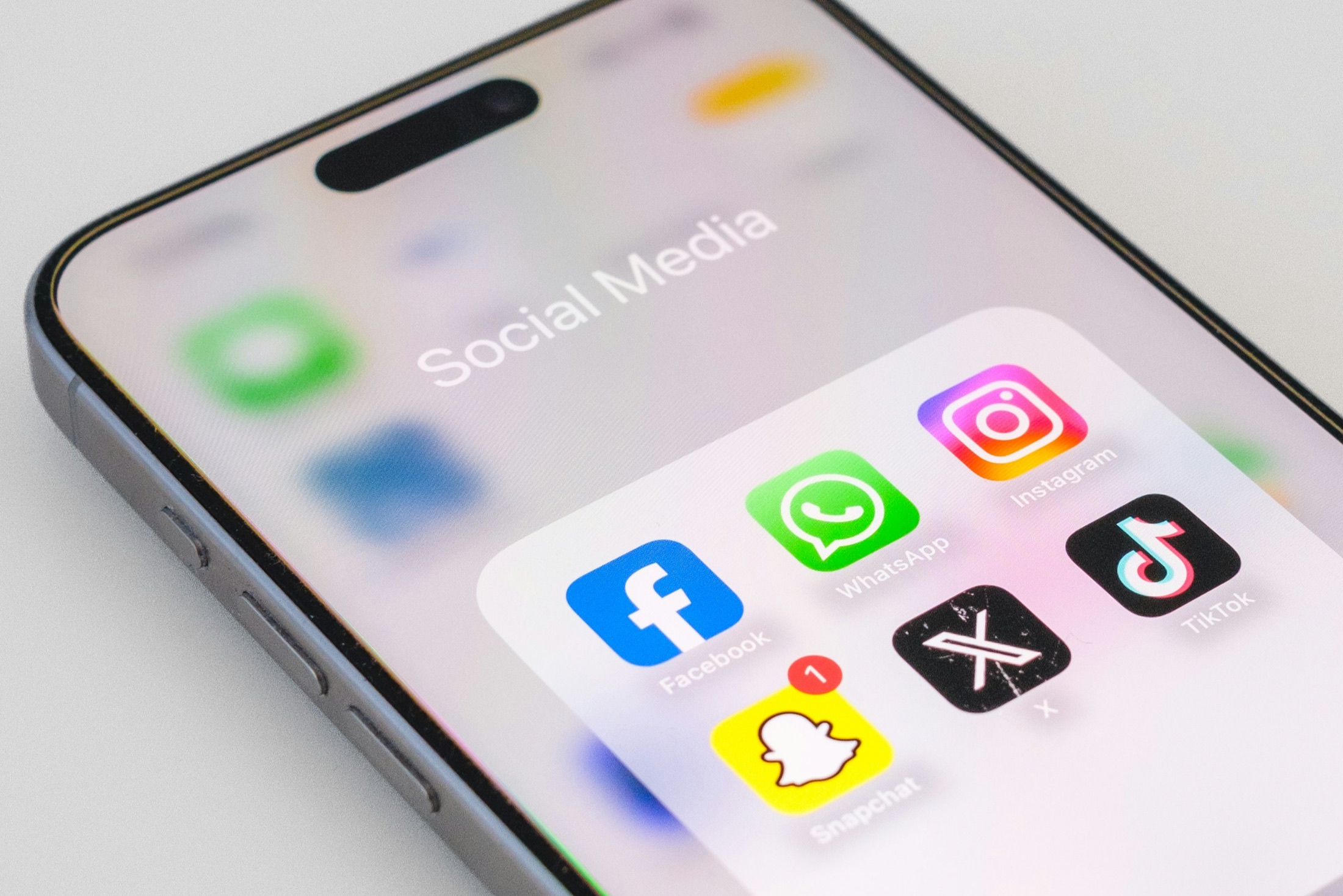 Close-up of a smartphone displaying a folder of social media apps